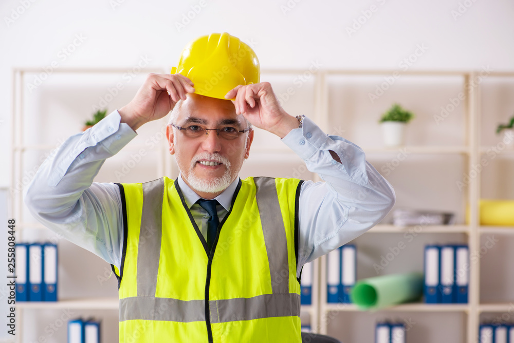 Aged construction engineer working in the office Aged construction engineer working in the office