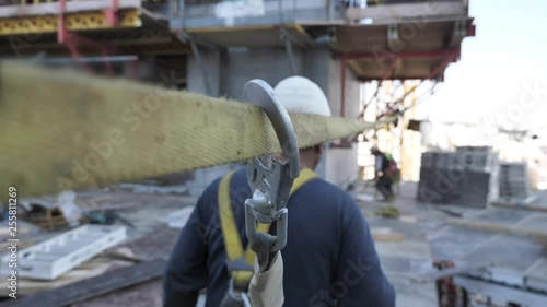 Construction worker connects a safety harness