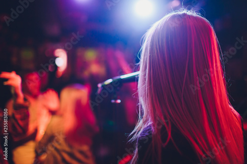 Entertianment at a wedding. A female singer is interacting with the crowd while a man plays an acoustic guitar.