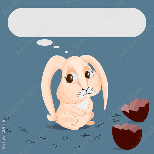 The beige rabbit is looking sadly at a broken chocolate egg and traces of a bird. Egg shell halves. Concept of losing a friend. Place for text.