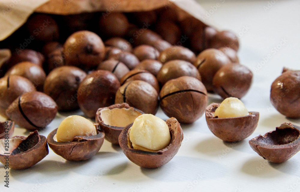 Organic macadamia nuts in craft bag on white table Organic macadamia nuts in craft bag on white table