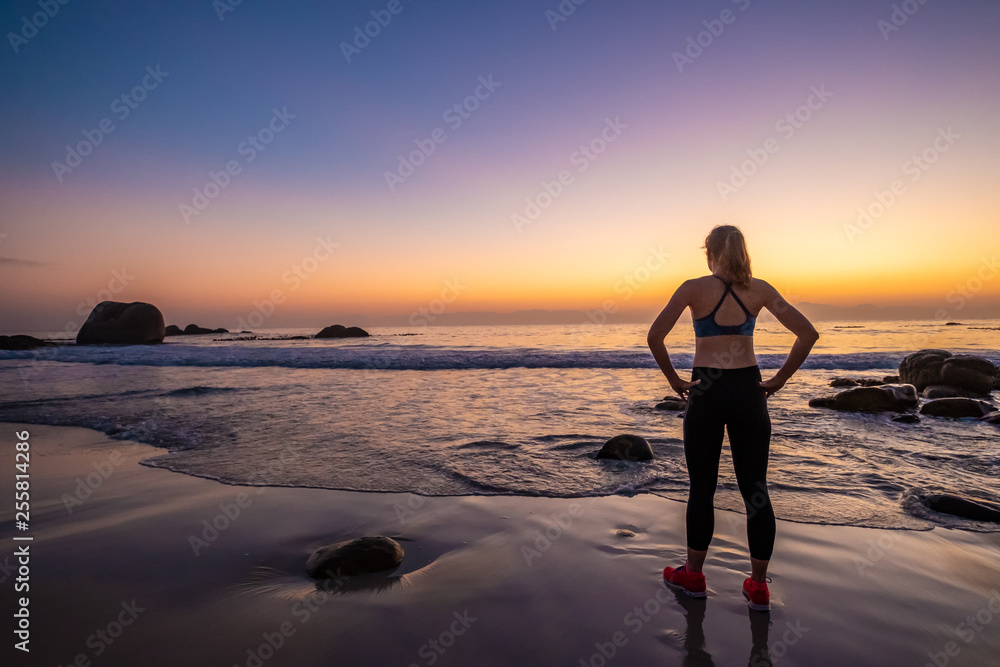 female athlete doing yoga on a beach