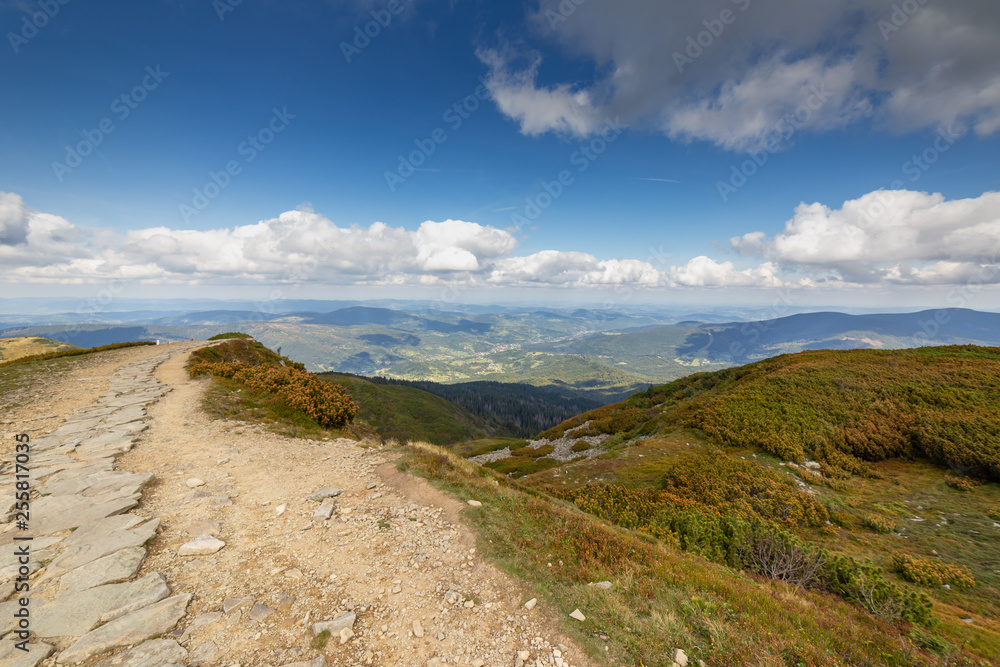 Hiking trail to Mala Babia Gora Mountain from Przelecz Brona Pass in Polish Beskid. High mountains landscape under blue sky with clouds.