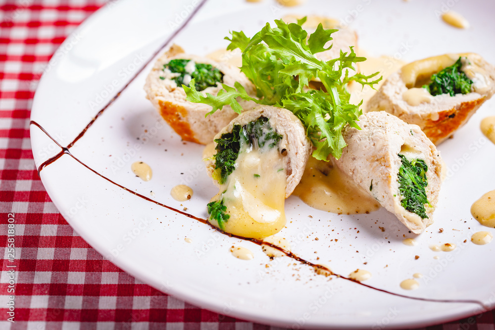 Steamed chicken cutlets stuffed with spinach on white plate. Close up Steamed chicken cutlets stuffed with spinach on white plate. Close up