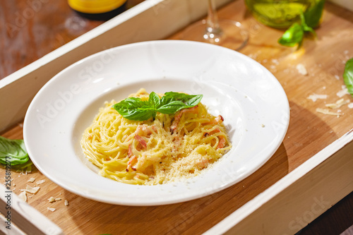 Italian spaghetti Carbonara with bacon and cheese on white plate. Close up