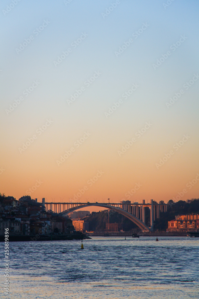 Naklejka premium view of ponte da arrabida from gaia in porto, portugal at sunset with blue and orange sky