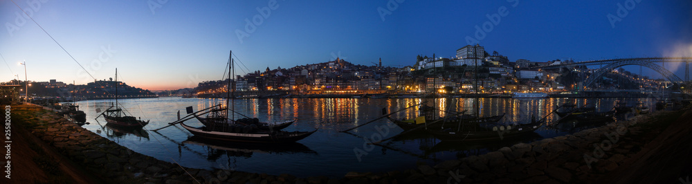 porto city skyline sunset panorama by night from ribeira houses with port wine boats at blue hour