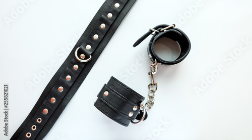 BDSM leather sex attributes: handcuffs, leather belt, collar