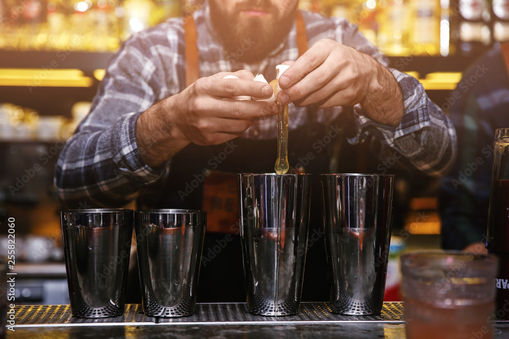 Bartender preparing tasty cocktail at counter in nightclub, closeup