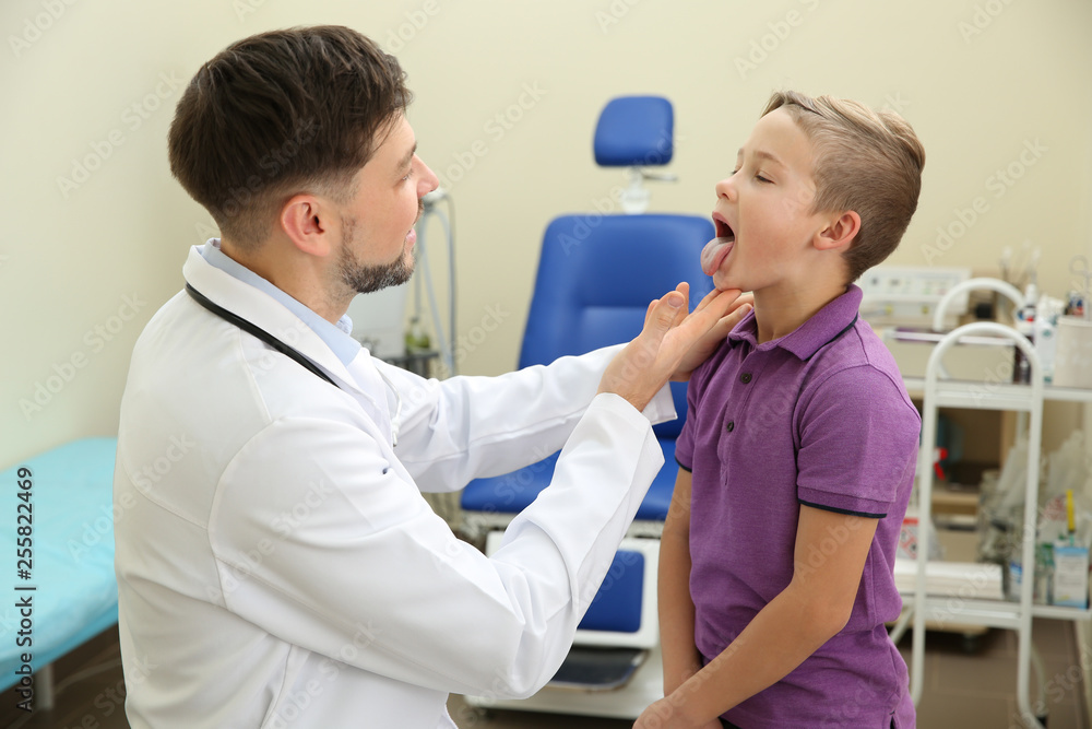 Fototapeta premium Male otolaryngologist examining little child in hospital