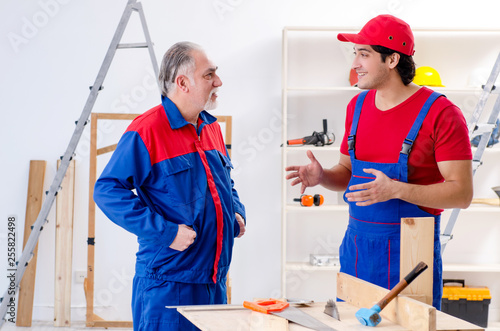 Two professional contractors laying flooring at home 