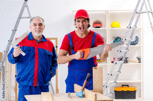 Two professional contractors laying flooring at home 