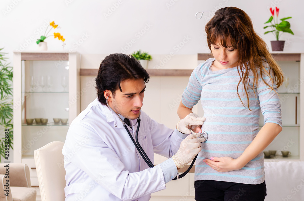 Young handsome doctor visiting pregnant woman at home Young handsome doctor visiting pregnant woman at home