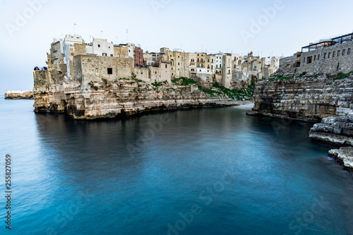 Polignano a Mare, Puglia - Italy. Sunset at Cala Paura gulf with Bastione di Santo Stefano and Lama Monachile beach on background photo