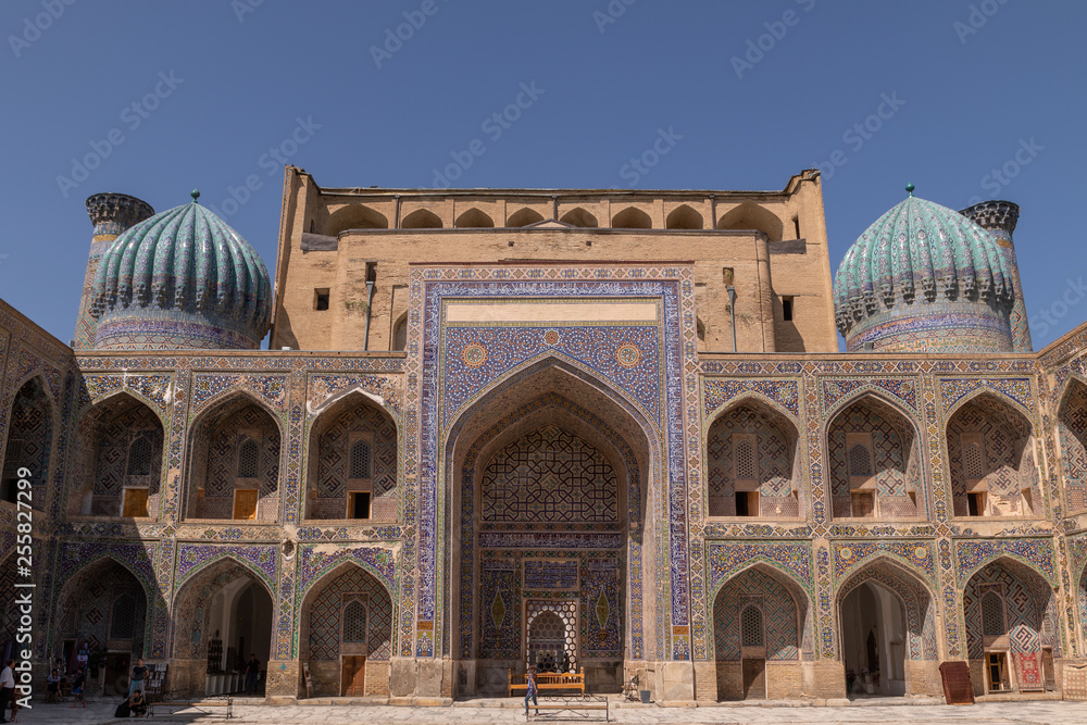 Madrasah Sher-Dor view from the yard. In the courtyard of the Madrasa. Inside the Madrasah on Registan square in Samarkand. Ancient Madrasah in Uzbekistan. Sunny summer day in an ancient city.