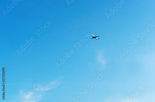High in the sky is an airplane. An airplane in the blue sky.