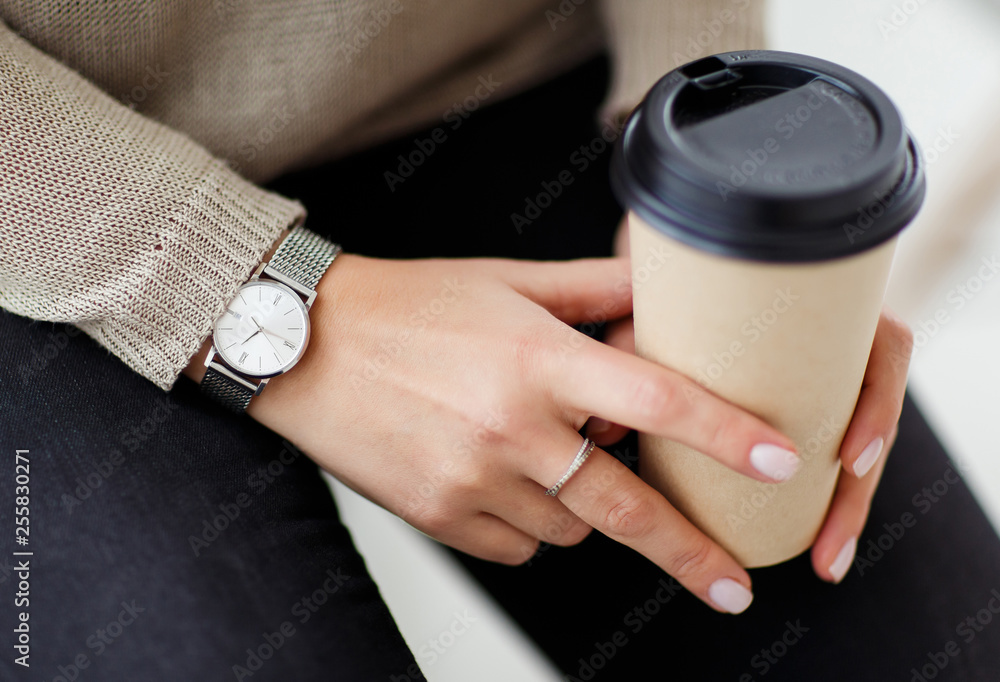 Woman holding glass of coffee in hands.
