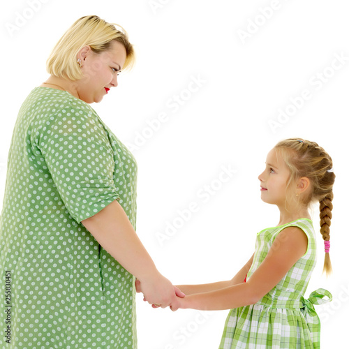 Mom and daughter hold hands.