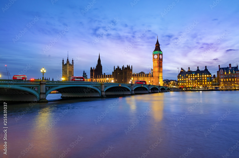 London cityscape with Big Ben and City of Westminster Abbey bridge illuminated in evening light, in England