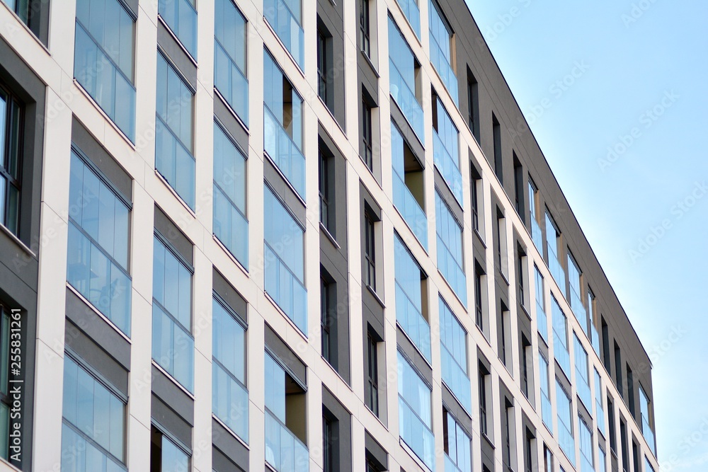 Multistory new modern apartment building. Stylish living block of flats. Modern, new executive apartments and with deep blue summer sky Multistory new modern apartment building. Stylish living block of flats. Modern, new executive apartments and with deep blue summer sky
