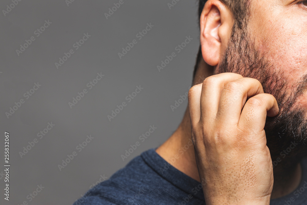 Closeup view of a man scratching beard, thoughtful gesture