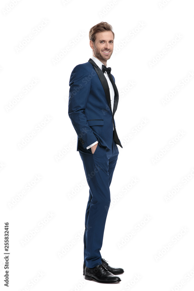 attractive man in blue costume standing with hands in pockets attractive man in blue costume standing with hands in pockets