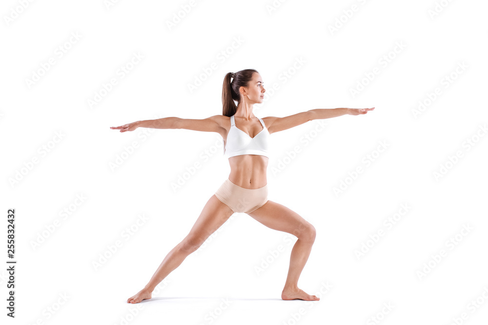 Attractive young woman doing yoga exercise Virabhadrasana, isolated on white background. Attractive young woman doing yoga exercise Virabhadrasana, isolated on white background.