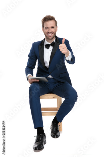 sitting man is making ok gesture with thumb up