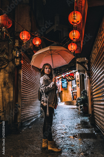Obraz na płótnie A woman poses on the famous Old Street of Jiufen, Taiwan at night. w salonie