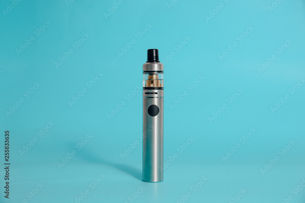 Silver e-cigarette on a blue background. Concept of smoking cigarettes, quitting smoking cigarettes. Health damage caused by smoking. Problems with the lungs, lung cancer. Silver e-cigarette on a blue background. Concept of smoking cigarettes, quitting smoking cigarettes. Health damage caused by smoking. Problems with the lungs, lung cancer.