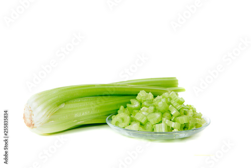 Cut and whole celery isolated on white background. Top view of vegetables. Concept of eating vegetables, using vegetables for dishes. Dish for a vegetarian. Healthy nutrition, vitamins.