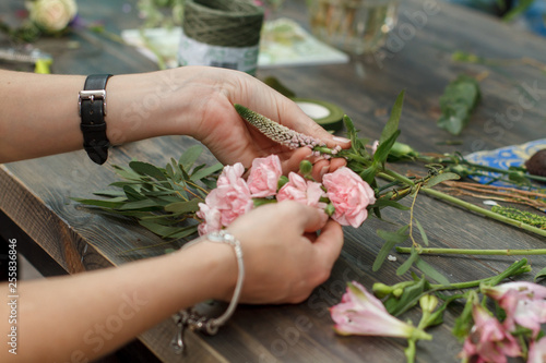 Florist at work: Creating a wreath of pink flowers and green branches