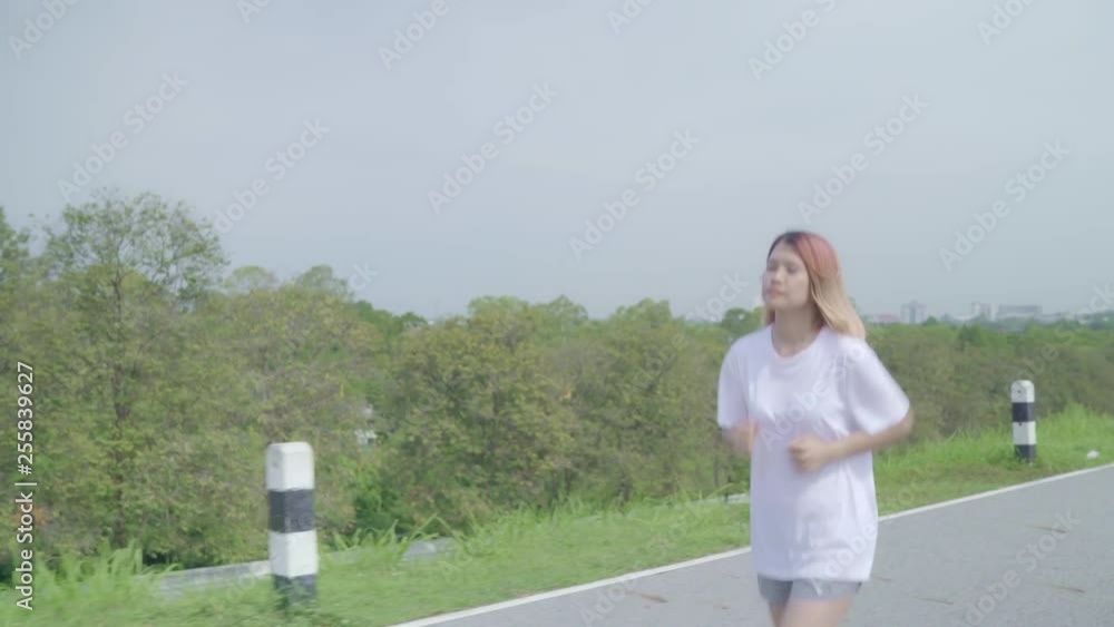 Asian runner woman running and jogging on street, Healthy beautiful young sporty female exercise near lake. Lifestyle fit and active women exercise on street concept. Asian runner woman running and jogging on street, Healthy beautiful young sporty female exercise near lake. Lifestyle fit and active women exercise on street concept.