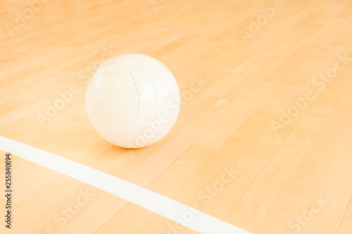 White volleyball on the ground in the school gym