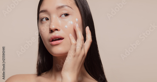 Applying moisturizer to her face
