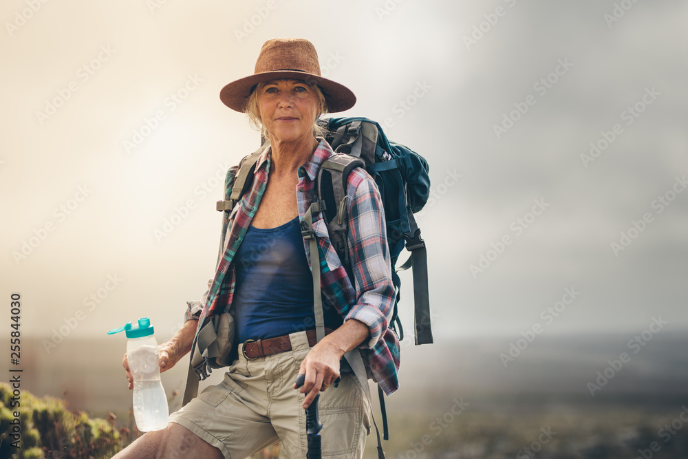Woman hiker drinking water during her trek Woman hiker drinking water during her trek