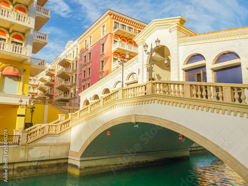 Venetian bridge on canals of picturesque district of Doha, Qatar. Venice at Qanat Quartier in the Pearl-Qatar, Persian Gulf, Middle East. Famous tourist attraction at sunset light.
