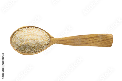 dried garlic powder in wooden spoon isolated on white background. spice for cooking food, top view.