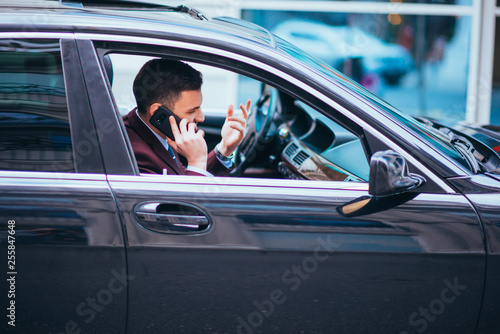 A serious businessman is having a conversation on his phone while looking sharp with his suit and tie. © qunica.com
