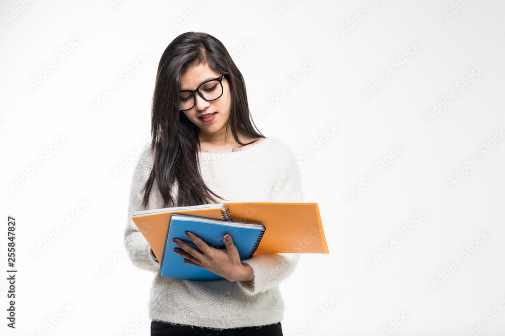 Portrait of attractive asian indian student woman standing holding reading a book with copy space over white background. Education test exam thinking concept Portrait of attractive asian indian student woman standing holding reading a book with copy space over white background. Education test exam thinking concept