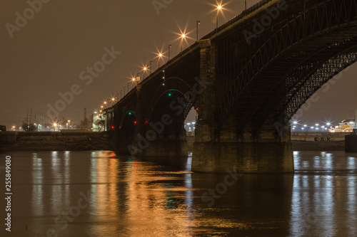 Classic stone bridge over Mississippi River with calm water at night with lights reflecting © Richard