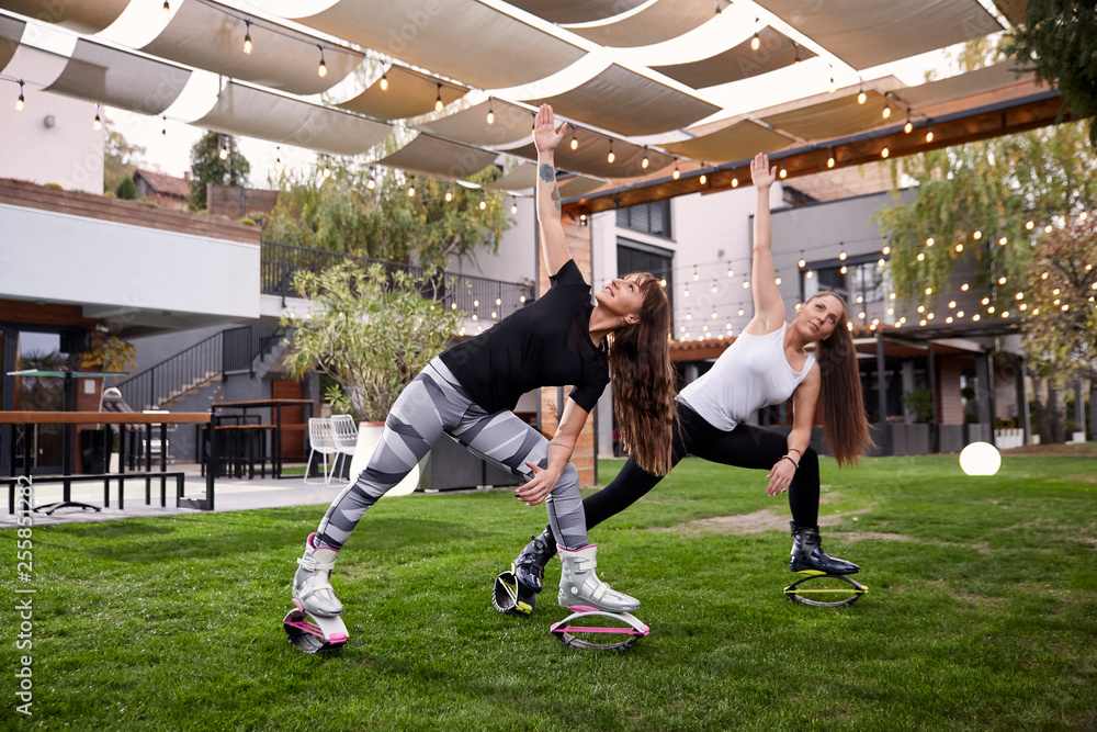 two young ladies 20 29 years old doing some kind of exercise in
