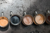 Set of colored samples of Balinese coffee in glass mugs on a stone table.