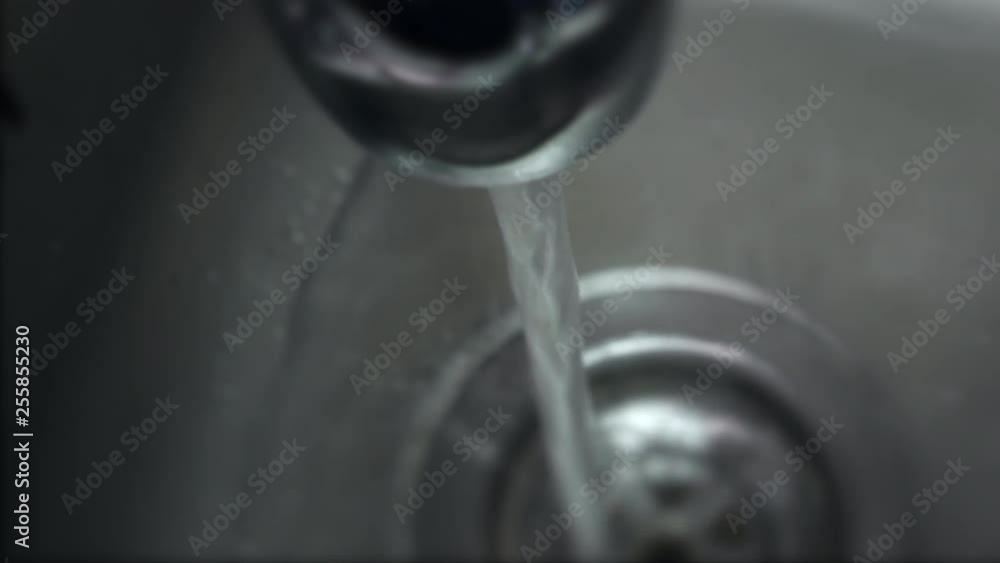 Top down view over stainless steel sink with running water from tap. Shallow depth of field Top down view over stainless steel sink with running water from tap. Shallow depth of field