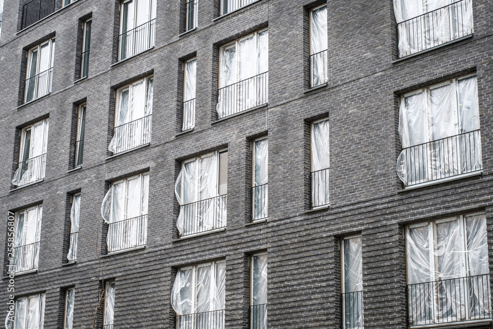 new apartment building complex with covered windows - new flats ,