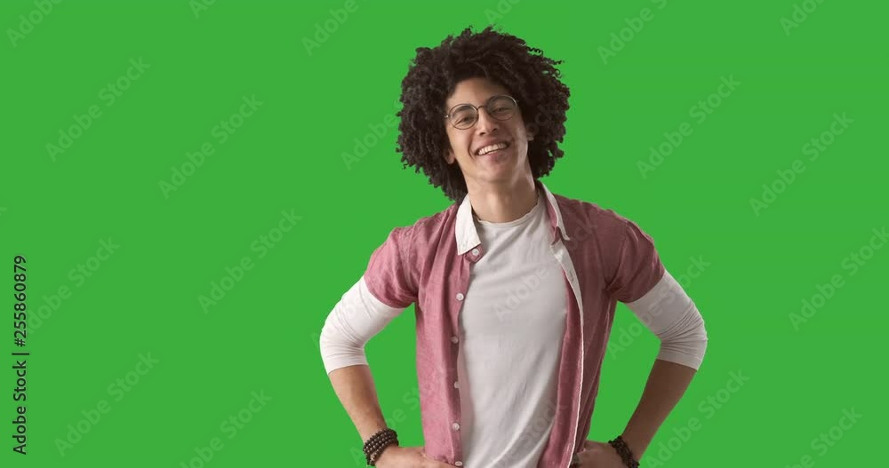 Portrait confident young man with curly hair smiling over green background Portrait confident young man with curly hair smiling over green background