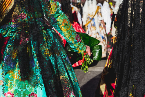 Valencia, Spain - March 17, 2019: Detail of the typical fallero dress, during the colorful and traditional parade of the offering, handmade embroidered dresses for the falleras.