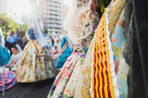 Valencia, Spain - March 17, 2019: Banda and Valencian flag decorating the typical Valencian fallera dress, worn by the beautiful women of Fallas. photo