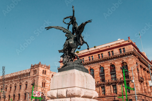 lose up of a famous sculpture situated outside Bellas Artes palace and the famous "Palacio postal" in the back on blue sky