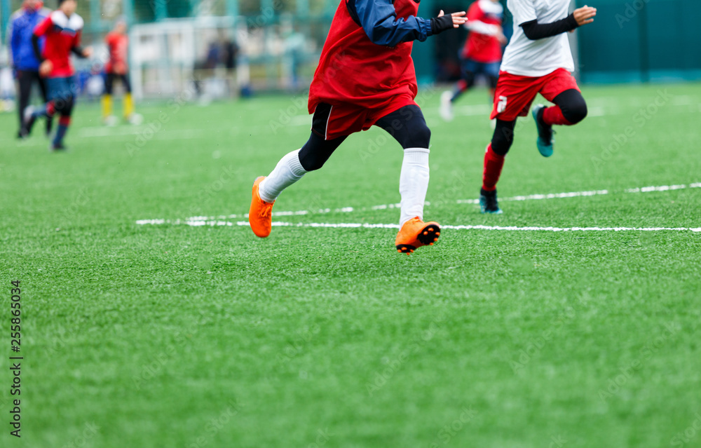 Obraz premium Football training soccer for kids. Boy runs kicks dribbles soccer balls. Young footballers dribble and kick football ball in game. Training, active lifestyle, sport, children activity concept 